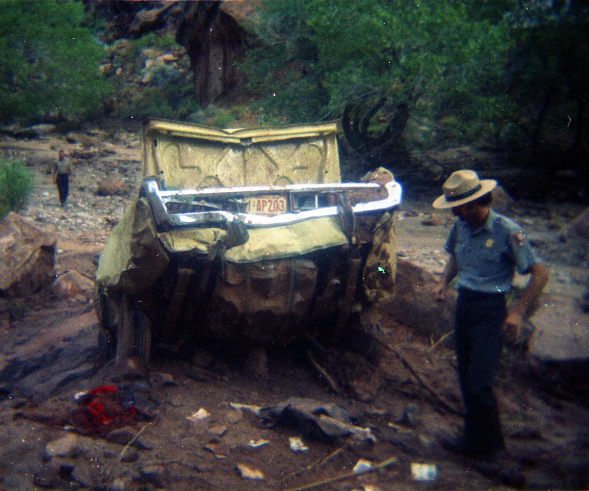 Color photos of park personnel removing a car from the flood waters of the 1975 flood.