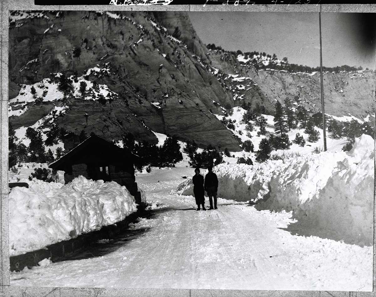 Snow covered east entrance, with couple standing in plowed road.