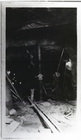 Worker using jack and drill in large tunnel.