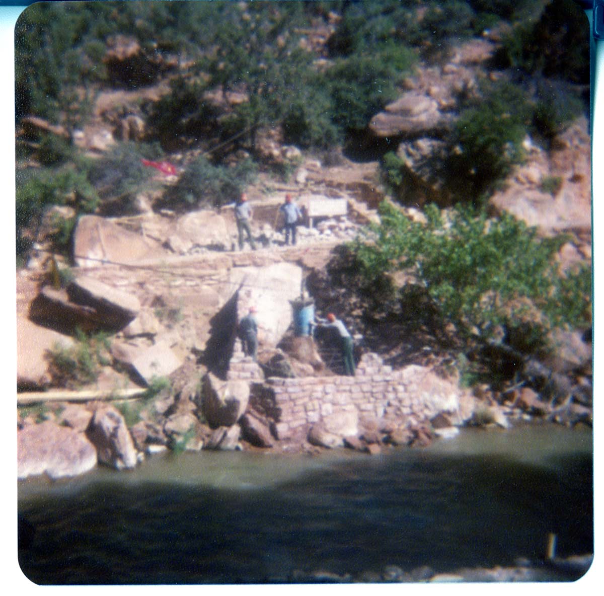 Men building stone abutment for the new Grotto footbridge.