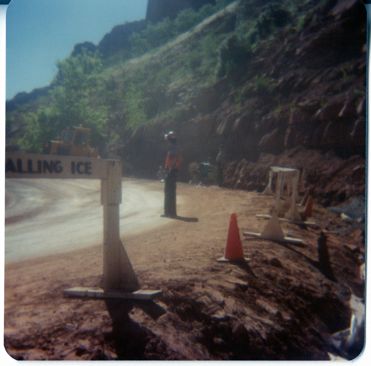 Men standing on side of road monitoring traffic during road construction.