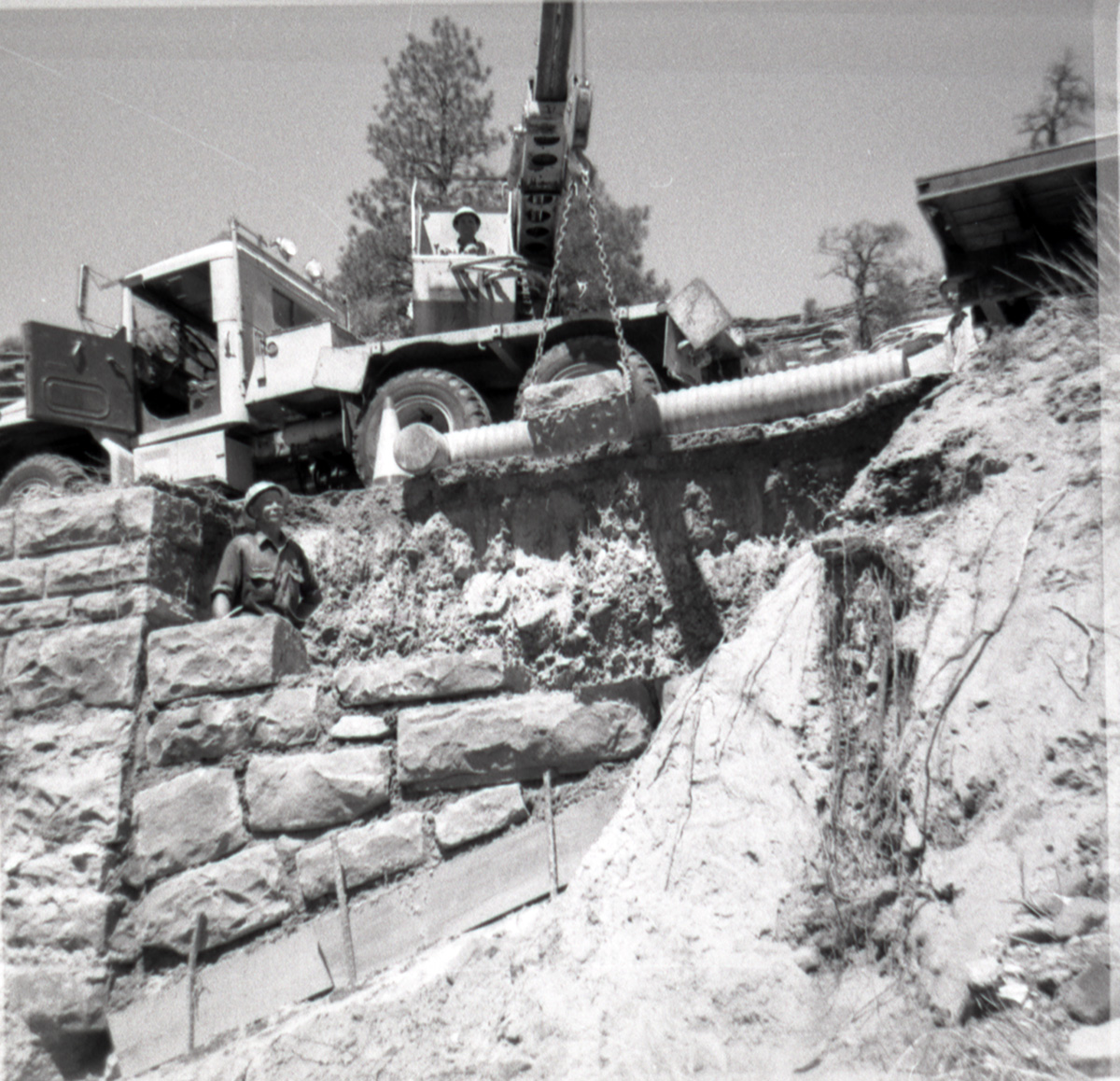 Crane being used for rock placement during the repair of a retaining wall along East Rim road.
