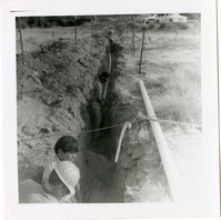 Workers digging ditch during the Watchman housing utility project.