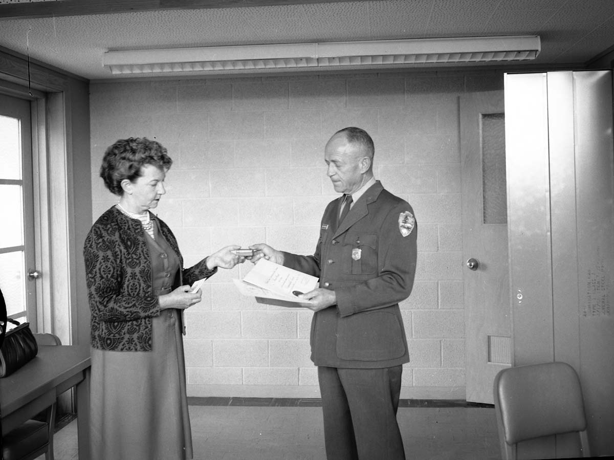Superintendent Oberhansley presents award of meritorious service to Mrs. Elsa Ruesch at her retirement after 30 years of service.