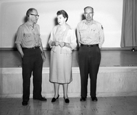 Sonehocker, Ruesch, and Heaton standing at the Mission 66 Visitor Center and Museum auditorium with their Service Award pins for 30 years of service.