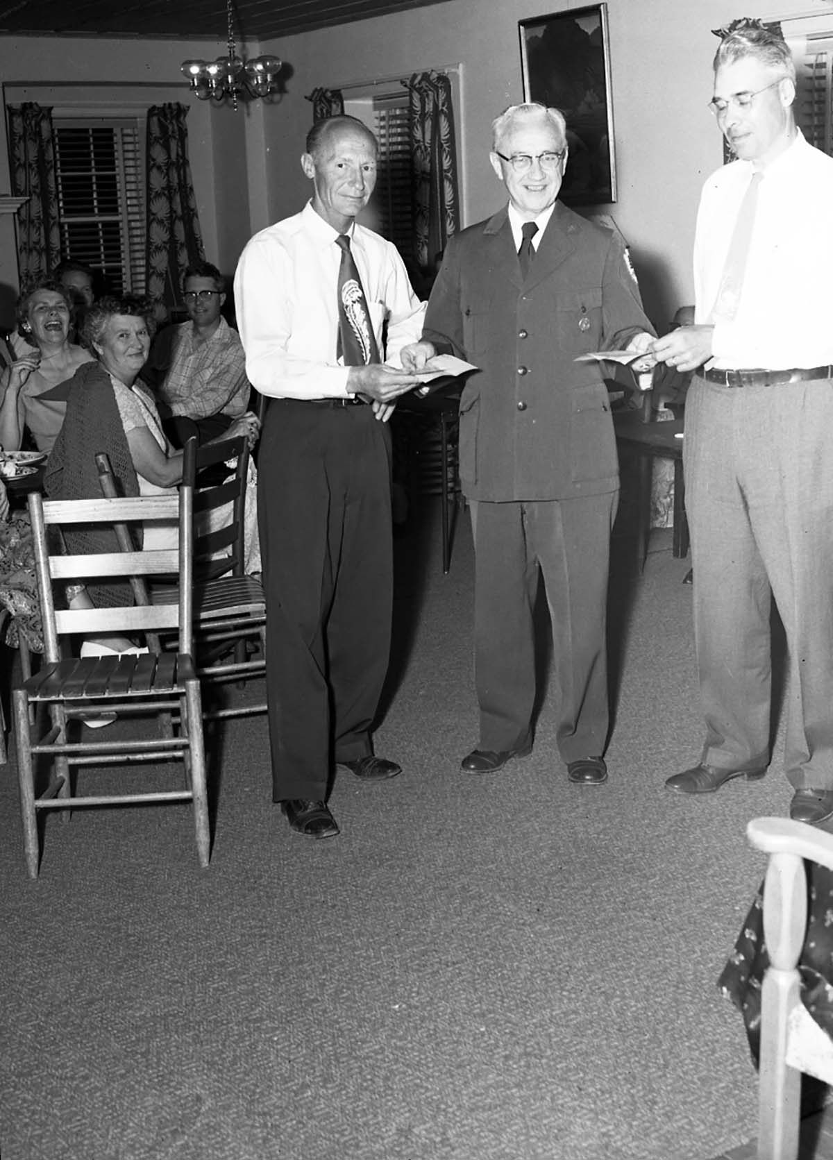 Superintendent Paul R. Franke presenting awards to Wilcox and Campbell at the ranger dormitory.