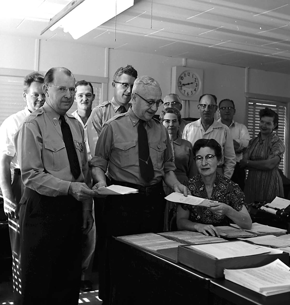 Superintendent Paul R. Franke presenting awards to Ruth Byrd and Carl E. Jepson with members of office staff present, administration building.