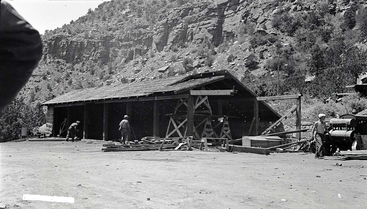Maintenance employees dismantling an equipment shed at the utility area.