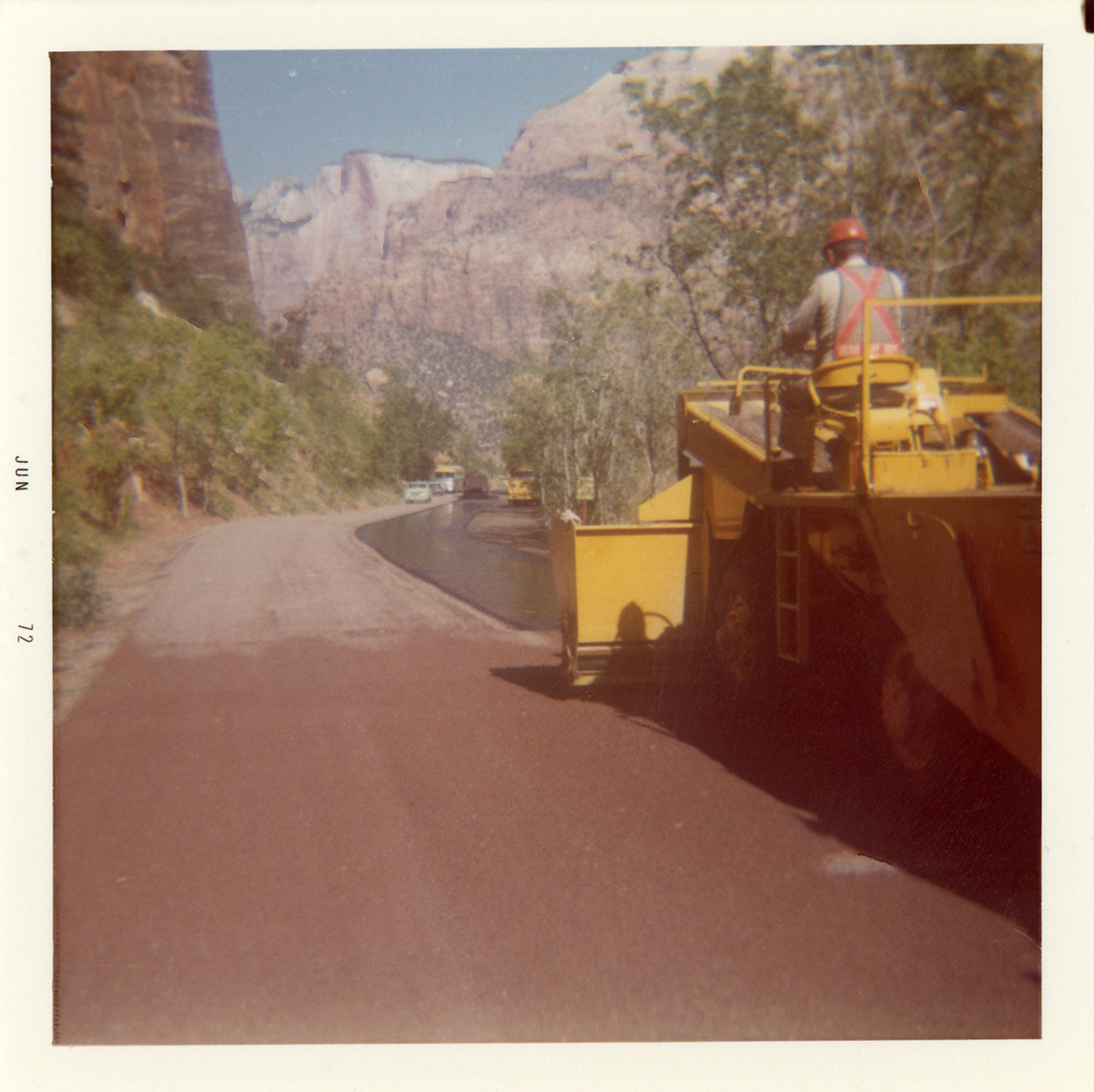 Man operating chipsealing vehicle during chipsealing of Zion roads.