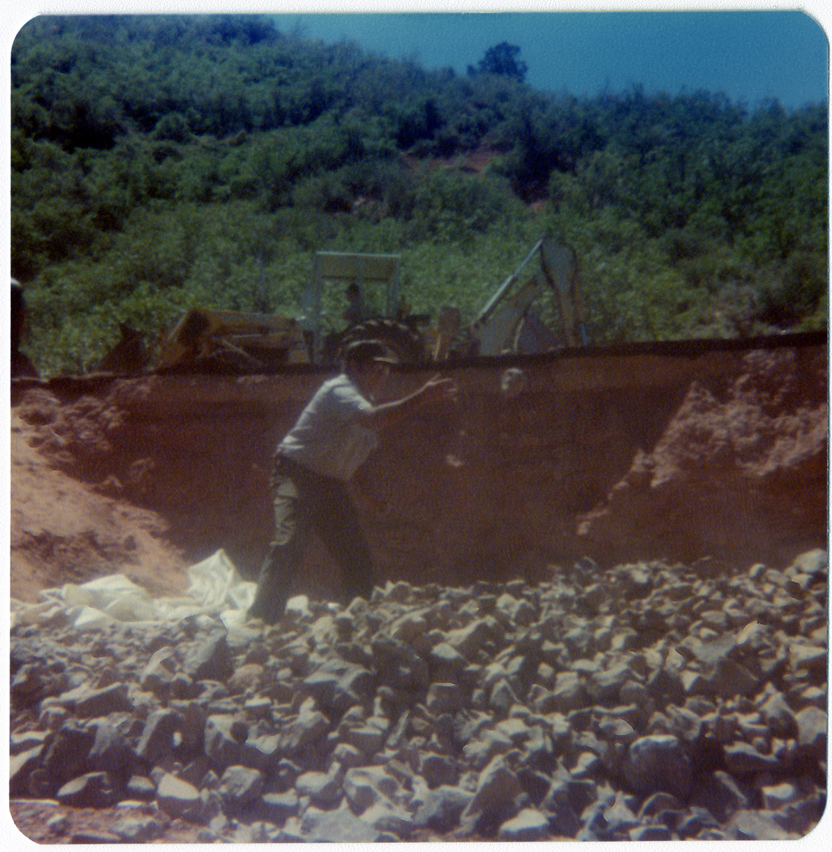 Man tossing rocks into rock pile during road work/repair in Kolob Canyon.