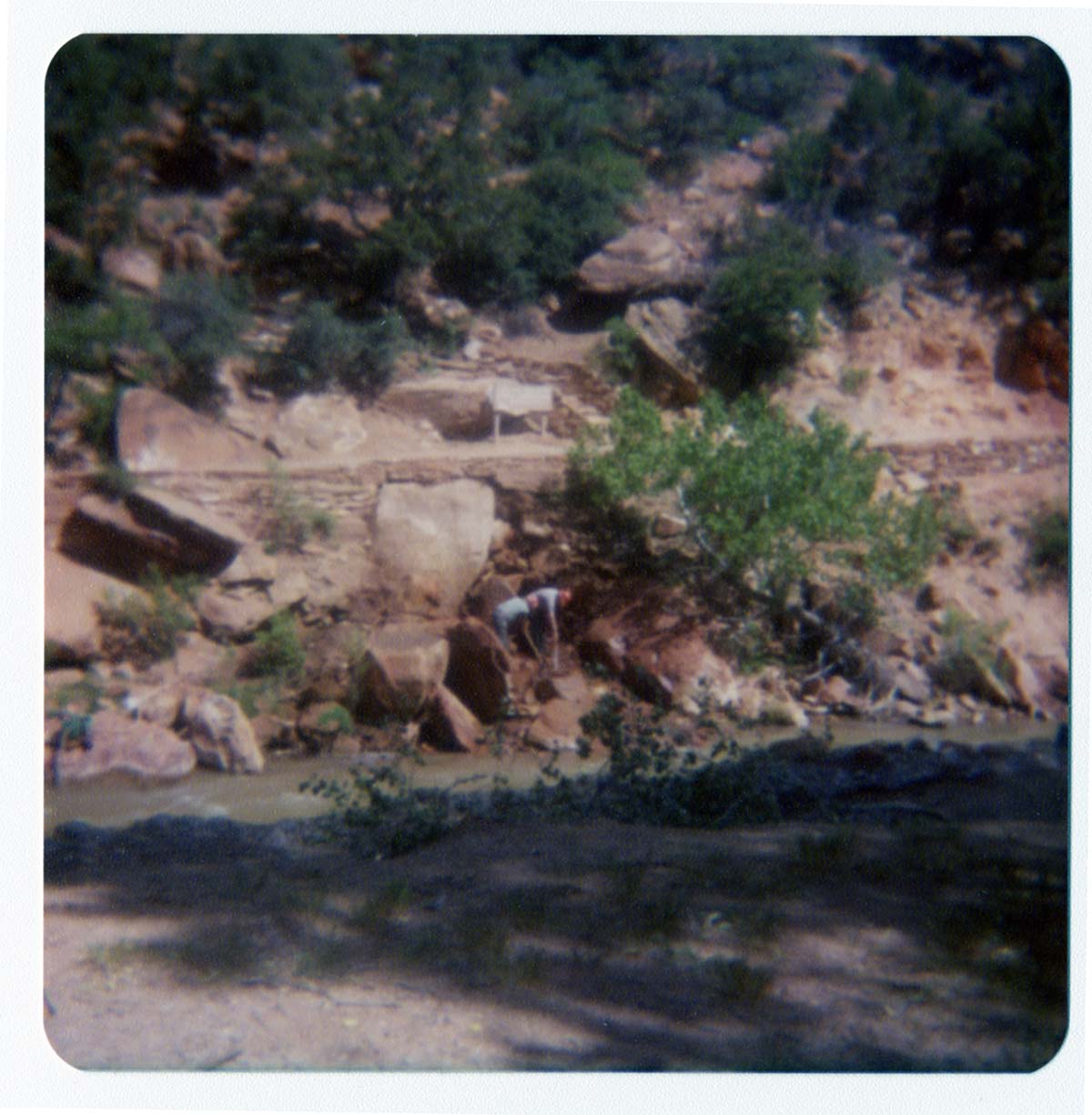 Two men using hoses to clear rubble from banks of Virgin River, in anticipation of constructing abutment for new Grotto footbridge.