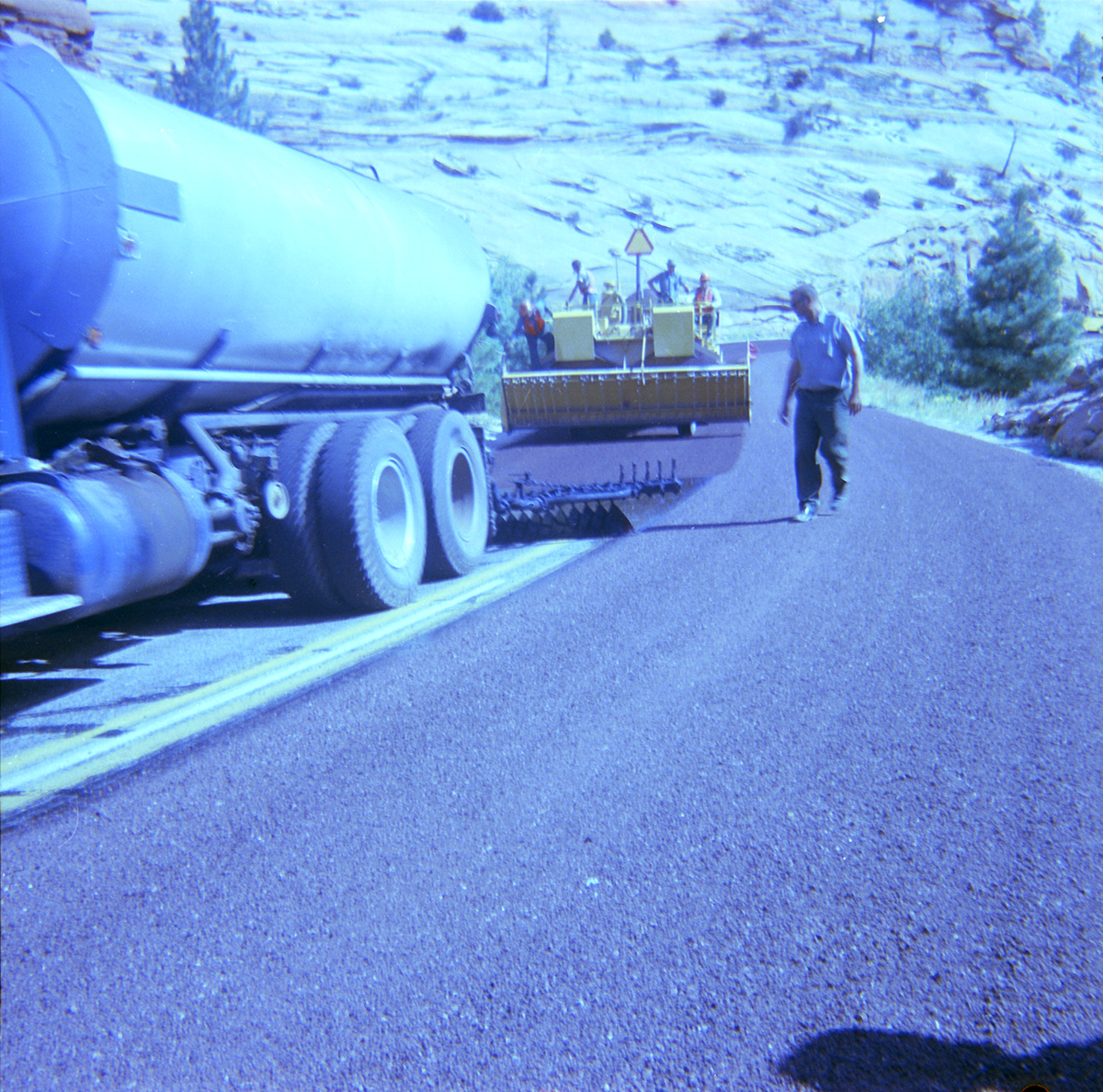 Man inspecting chipsealing job being performed on the roads.