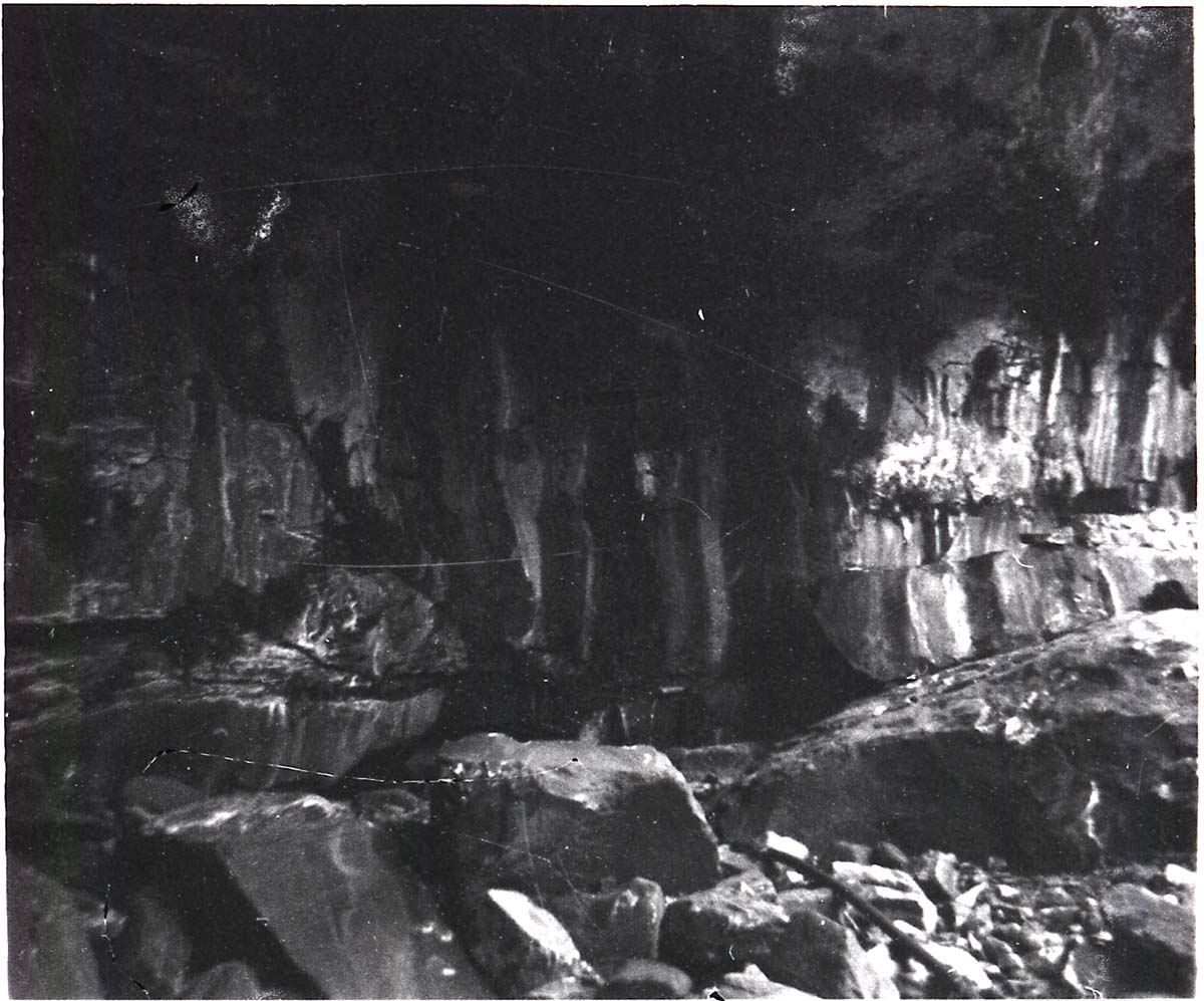 Spring with pipe near base of canyon wall.