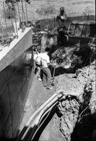 Men working with shovels during construction of headquarters addition.