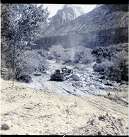 Clearing the right-of-way for new highway, from South Entrance Station to Virgin River Bridge. Bulldozer clearing and scraper collecting top soil (in background).