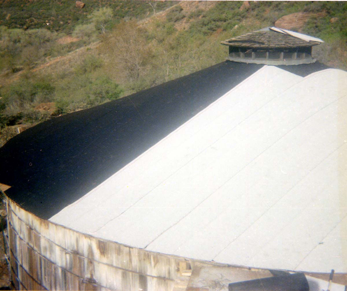 Water tank with new roof in progress, during reroofing project.