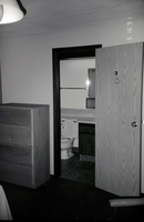 Bedroom and bathroom in barracks. [Image possibly for comparative housing study]