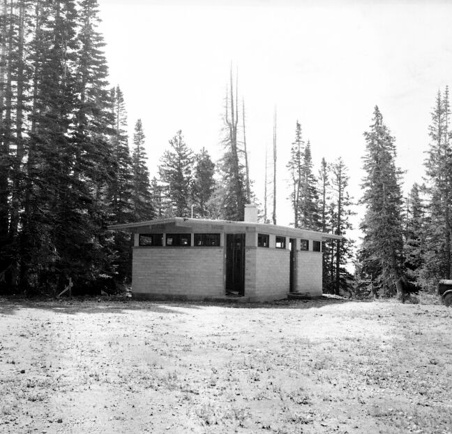 Comfort station nearing completion of construction along edge of forest.