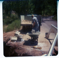 Man filling wheelbarrow with construction materials for the construction of the Springdale water pipeline.