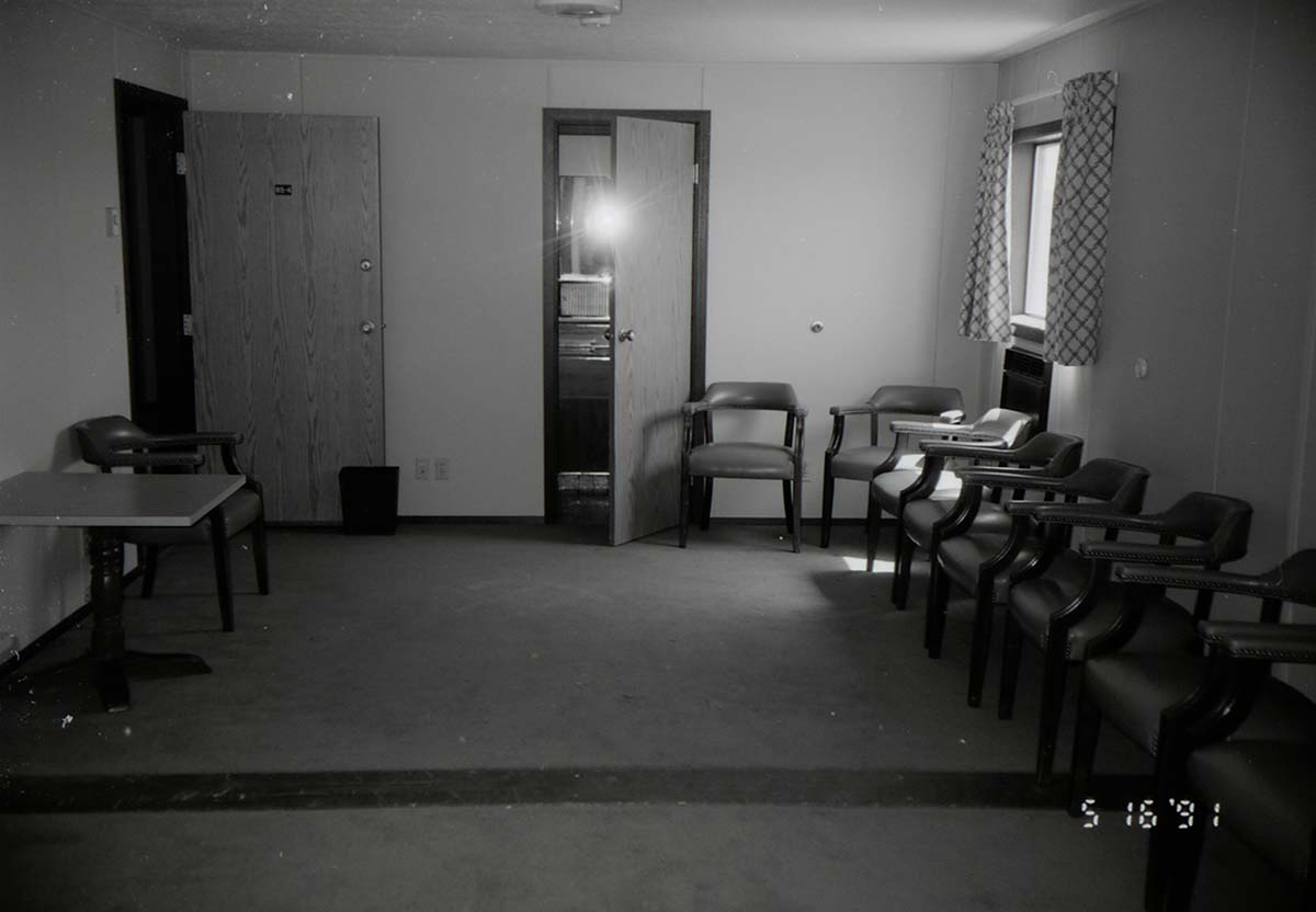 Chairs along wall of living room area in barracks. [Image possibly for comparative housing study]